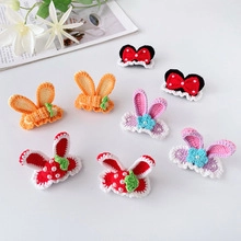 Flat lay of handmade knit hair clips featuring carrot bunny ears and strawberry designs