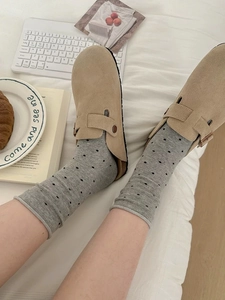 Gros plan de mules en daim kaki avec boucle métallique réglable dans un cadre domestique
