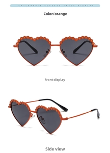 Detail of heart-shaped kids' sunglasses with orange floral accents and metal temples