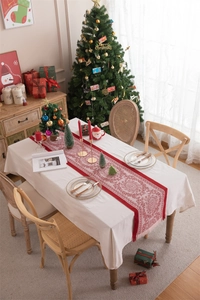 Close-up of red Christmas table runner with white jacquard patterns and handmade tassels