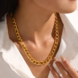 Fashionable gold plated stainless steel figaro chain necklace worn on a white shirt