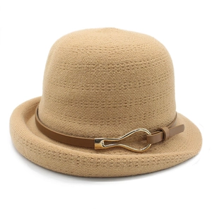 Detail of khaki knitted cloche hat featuring dark brown leather strap and gold buckle