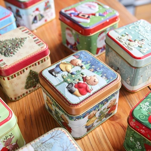 Embossed Christmas tin gift box collection with Seasons Greetings on wooden surface