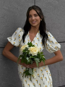 Detail of floral puff sleeve dress with yellow tulip print and pleated cotton texture