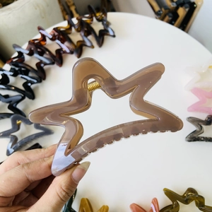Star-shaped hollow hair claw clip in brown acrylic with metallic spring for women