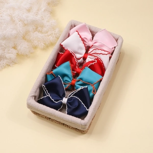 Close-up of assorted grosgrain ribbon bow clips in a woven basket storage display