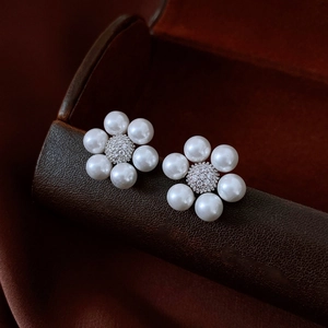 Macro shot of elegant pearl flower earrings featuring a brilliant center zircon stone