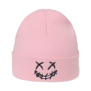 Close-up of pink knitted beanie featuring black embroidered XX face and graffiti smile
