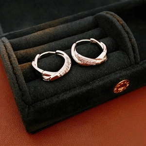Luxurious silver twisted hoop earrings with micro-pave cubic zirconia on black display
