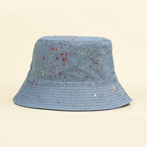 Détail d'un chapeau bob en denim bleu avec motif éclaboussures et bord surpiqué