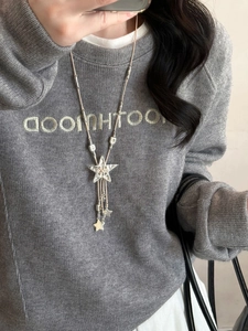 Detail of silver star tassel pendant on long bohemian leather rope sweater chain