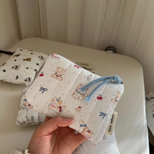 Detailed close-up of a quilted cotton mini pouch with bear and cherry patterns
