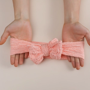Rosa Baby Stirnband mit großer Schleife aus dehnbarem Stoff in gedehnter Ansicht
