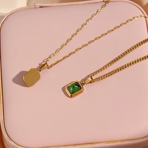 Gold plated stainless steel Figaro chains with green zircon and square pendants on jewelry box