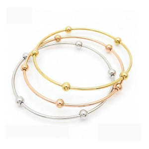 Three-piece set of polished stainless steel bangles in gold, rose gold and silver finish