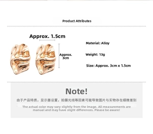 Detailed view of golden irregular textured alloy earrings with lava-like metal finish