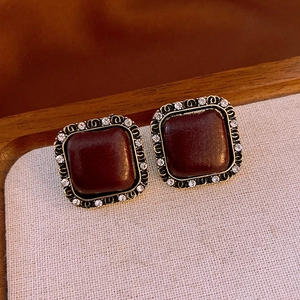 Close-up of vintage square stud earrings with brown center and sparkling rhinestones
