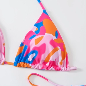 Détail du haut de bikini bicolore avec motif camouflage abstrait et cordon de serrage