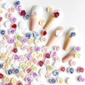 Detailed view of colorful 3D resin rose nail charms on gradient press-on nails