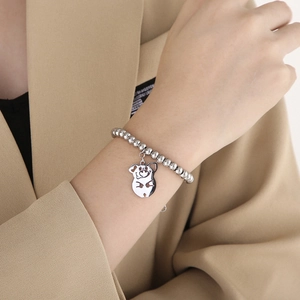 Polished silver beaded bracelet with a cute hollow pig charm on a model's wrist