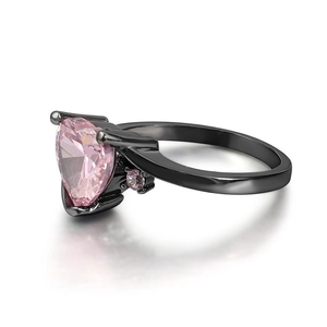 Detailed macro view of heart-shaped pink zircon set on a black gold finish ring band