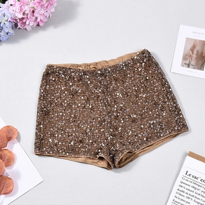 Gros plan d'un short à paillettes bronze avec taille élastique sur fond texturé