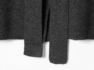 Gros plan détaillé de la texture en maille gris foncé et de la couture de l'ourlet