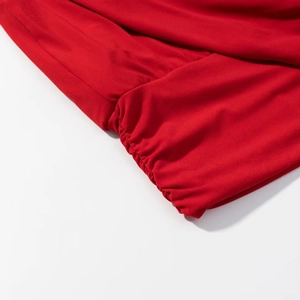Détail de tissu plissé rouge vif montrant des coutures précises et une texture douce