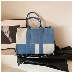 Detail of blue denim and beige canvas patchwork tote bag with removable shoulder strap
