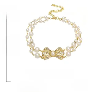 Dettaglio della collana di perle a due strati con un fiocco di strass scintillanti