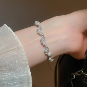 Elegant pearl and zircon bracelet shown on a wrist with silver adjustable chain detail