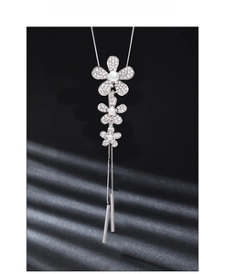 Macro shot of Y-shaped silver necklace with pavé diamond flowers and pearl tassels