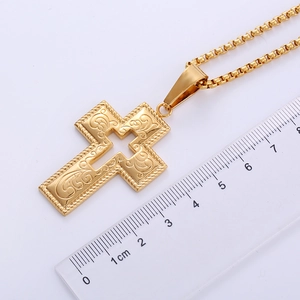 Close-up of gothic 18k gold plated stainless steel cross pendant with size ruler