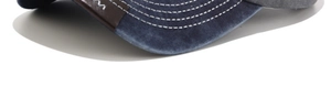 Macro detail of navy washed canvas brim with white stitching and leather patch accents