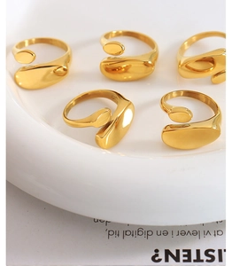 Close-up of minimalist 18k gold irregular rings with smooth polished finish on white surface