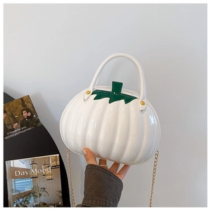 Detail of white glossy pumpkin bag featuring green leaf accents and gold chain strap