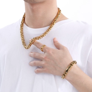 Dettaglio di set collana, bracciale e anello bizantino dorato indossato da modello
