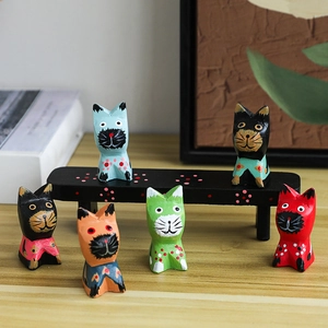 Handcrafted set of six colorful wooden cat figurines on a black bench for desk decor