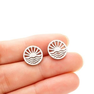 Minimalist silver geometric earrings with hollow sun and wave design held in hand