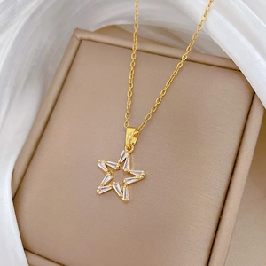 Detail of gold star pendant necklace featuring crystal inlay on a silk background