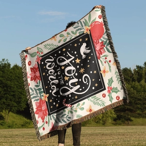 Close-up of Joy to the World woven throw blanket with colorful fringe and festive pattern