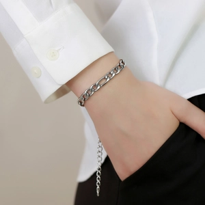 Detail view of silver Figaro chain bracelet on wrist with adjustable extension link