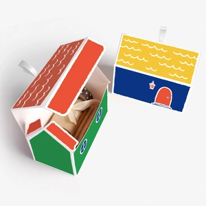 House-shaped gift box with silk ribbon handle in contrasting red green and blue yellow colors