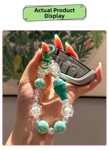 Mint green beaded keychain with ice cream cone pendant used on car keys in hand