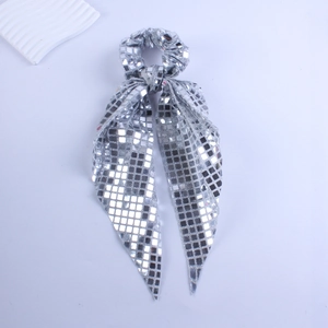 Detail of silver sequined hair scrunchie with long ribbon featuring reflective square mirror tiles