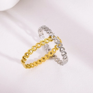 Detail of linked heart pattern bracelets in gold and silver finish with clasp