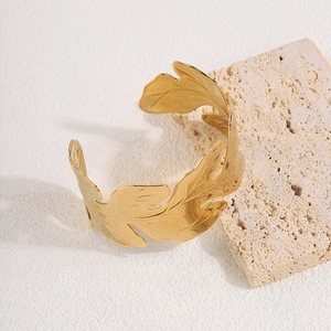 Detail view of adjustable gold leaf cuff bracelet with intricate botanical leaf patterns
