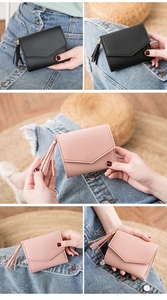 Dettaglio di portafogli minimalisti in ecopelle nera e rosa con nappe decorative