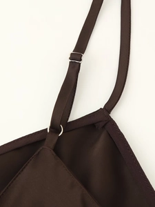 Detail view of dark brown satin dress showing adjustable strap with silver metal buckle