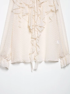 Detail der cremeweißen transparenten Bluse mit Punkt-Jacquard und Rüschendesign
